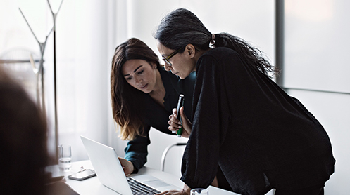 Women looking at a laptop in a modern office Women looking at a laptop in a modern office